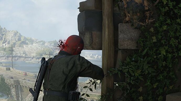 Sniper Elite 5 killcam screenshot of a bullet hitting an enemy soldier in the head as blood sprays out