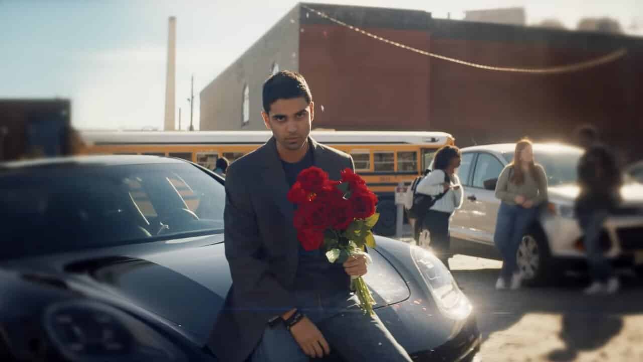Kamran stands in his car with roses in ms marvel