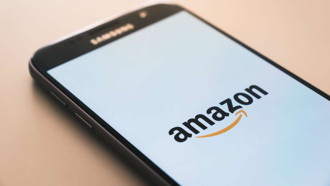 Mobile phone on a table with the Amazon logo on the screen