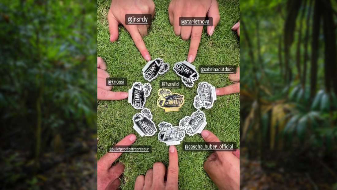 Hands of all participants of 7 vs Wild with medals
