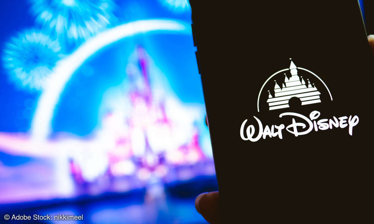 Smartphone with Disney logo in front of Disney Castle with fireworks